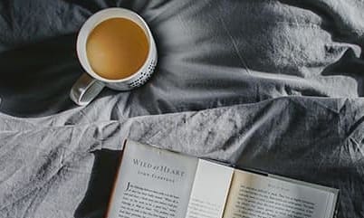 Coffee and book on bed