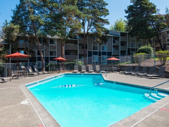 Swimming pool, lounge chairs, and umbrellas at Rolling Hills Apartments, Tualatin, 97062