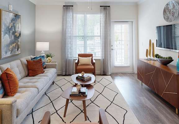 Living room with couch and chair; door to patio or balcony