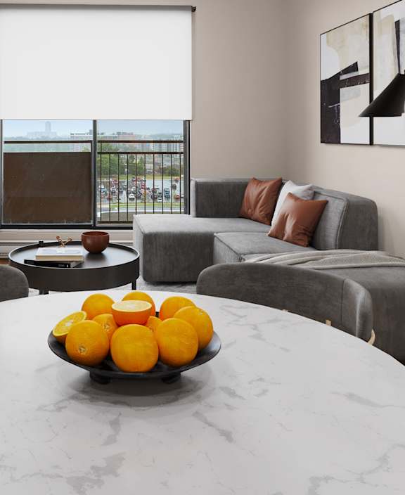 A living room with a white couch and a dining table.