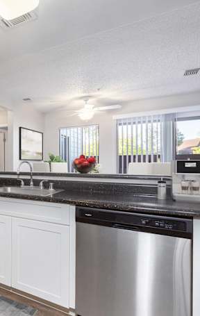 A modern kitchen with stainless steel appliances and white cabinets.