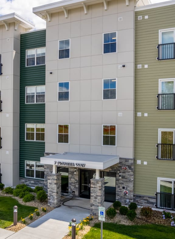 an apartment building with green and white walls and a sidewalk at Edgebrook Residences, New Hampshire