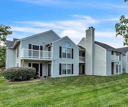 a large white house with a lawn and trees