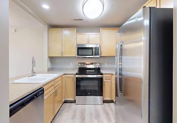 a kitchen with stainless steel appliances and wooden cabinets