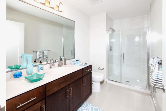 Modern bathroom with dual vanity and teal accent pieces