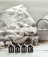 A cozy living room featuring a comfortable couch with a teapot and blanket, creating a warm and inviting atmosphere.