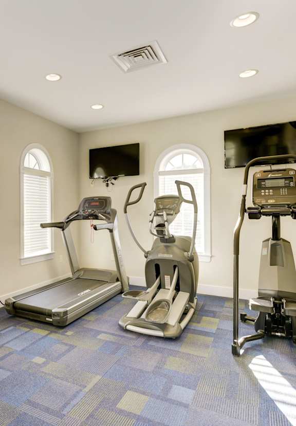 a home gym with exercise equipment and windows