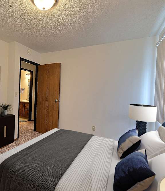 a bedroom with a bed and a dresser and a mirror