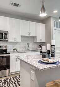 an open kitchen and living room with an island and stools