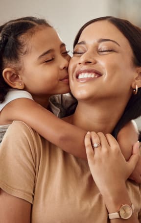 a little girl kissing a woman on her cheek