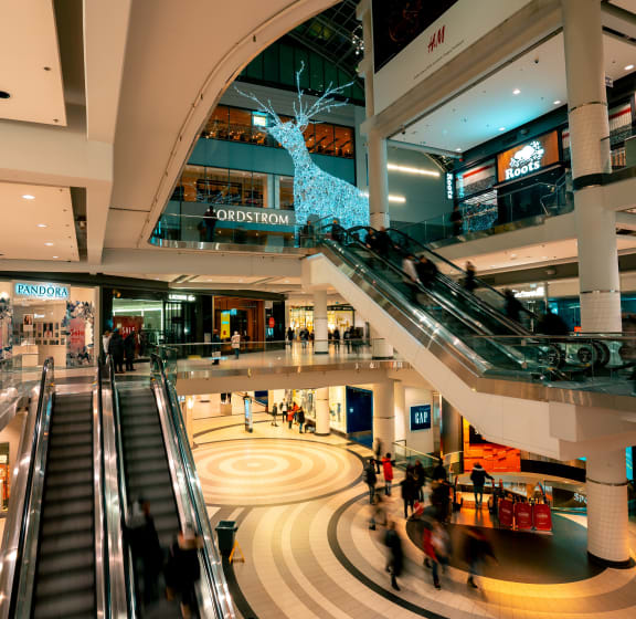 Stock image of large shopping mall from afar with an escalator going up and down.