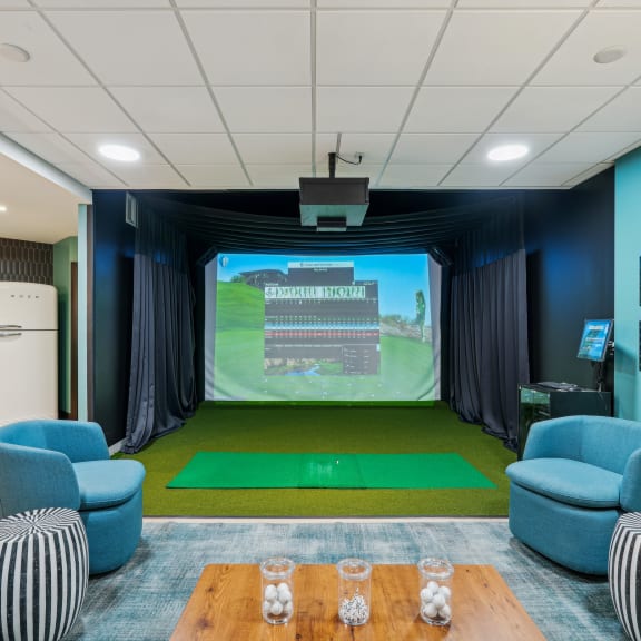 a room with a projector screen and chairs and a table