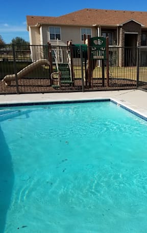 A family of four sitting on the floor surrounded by moving boxes. at Enclave Creedmoor Apartments, Creedmoor, TX, 78610
