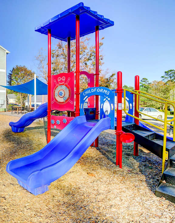 A playground with a blue slide and a red and blue tower.
