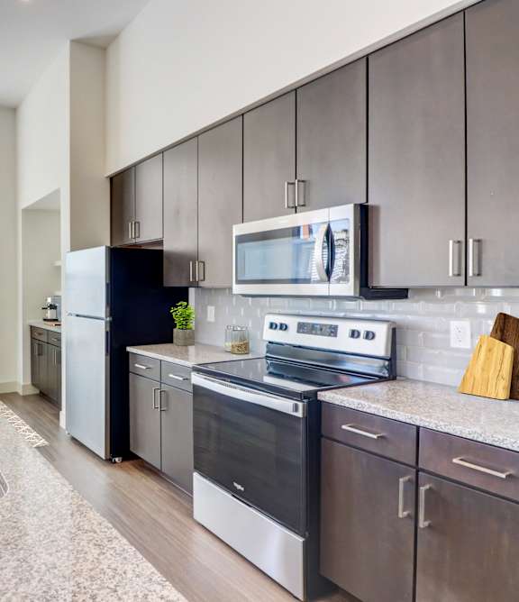 A modern kitchen with stainless steel appliances and a granite countertop.