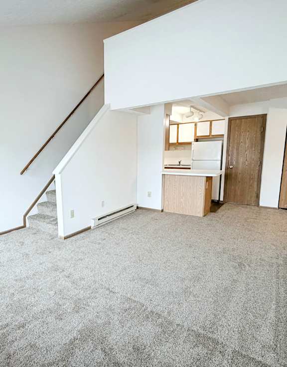 an empty living room with wood flooring and a blue door  at Wyndemere Apartments, Franklin, 45005