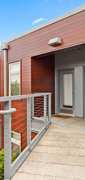 A wooden deck with a metal railing and a small table and chairs.