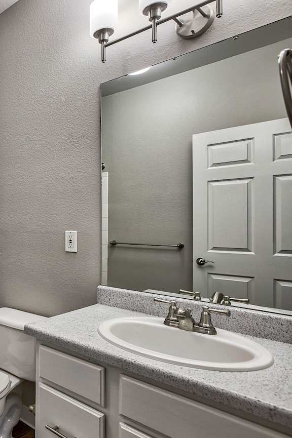 A bathroom with a toilet, sink, and shower.