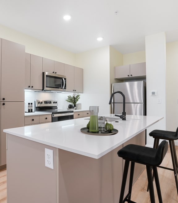 a kitchen with a large island with two stools