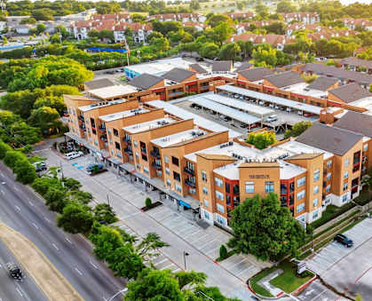 An aerial view of a large building complex with a parking lot in front.