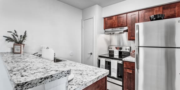 an updated kitchen with granite counter tops and stainless steel appliances