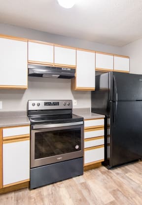 a kitchen with white cabinets and black appliances