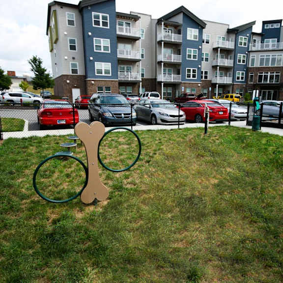 A playground with a swing set in front of apartment buildings.