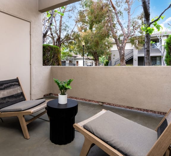 a balcony with two chairs and a table and a door