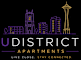 The image is a logo for U District Apartments, featuring a sticker design with a city skyline and the tagline "Eight Buildings. One Community.".