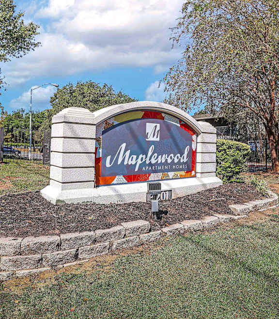 A sign for Maplewood is displayed in a landscaped area.