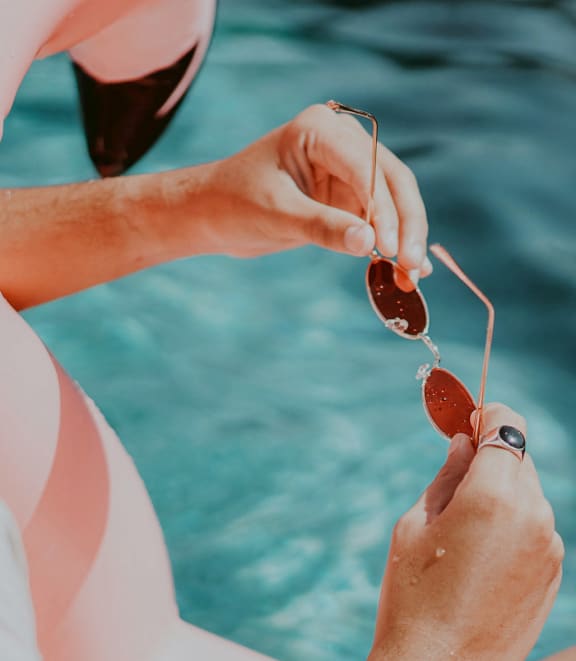 a man and a woman sitting by the water eating strawberries