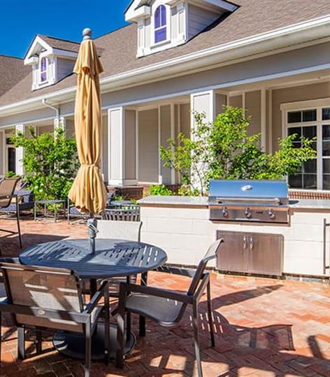 a patio with a table and chairs and a grill at Canopy at Ginter Park Apartments, Richmond, VA, 23227