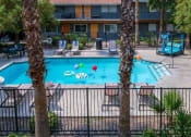 Thumbnail 12 of 23 - Aerial view of Community pool near Las Vegas strip at Fifteen 50 apartment buildings. Pool is surrounded by patio furniture and palm trees