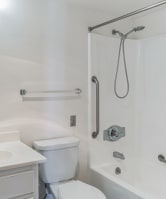 a bathroom with a toilet sink and shower and a mirror
