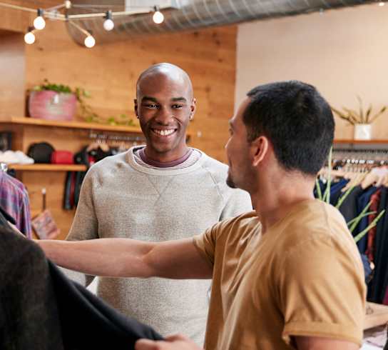 two men shopping for clothes in a clothing store