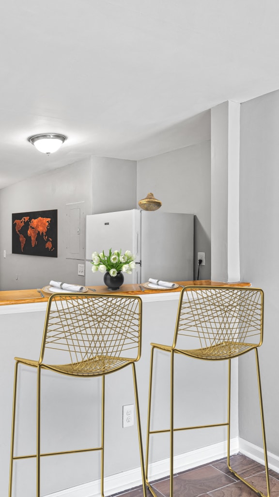 a kitchen with a bar and two stools at Gardens at Washington Park in Georgia 30314