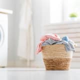 a basket filled with laundry sitting next to a washing machine