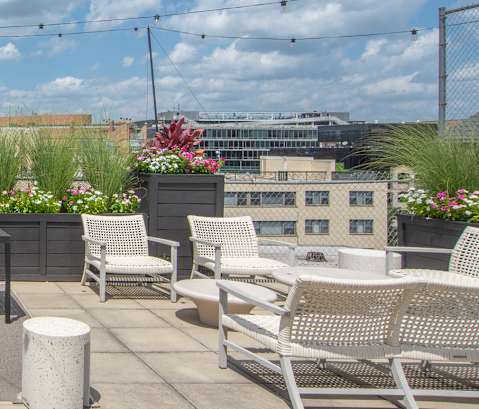 a rooftop patio with tables and chairs and a view of the city