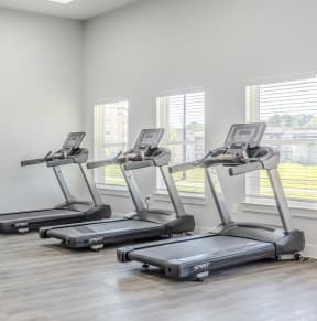 a gym with cardio equipment and weights