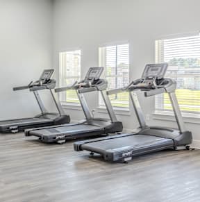 a gym with cardio equipment and weights