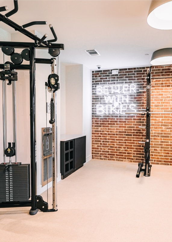 a home gym with a brick wall and exercise equipment