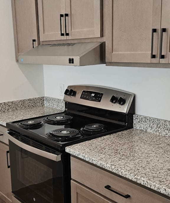 A kitchen with a stove top oven and a refrigerator.