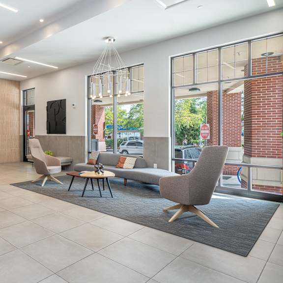 A spacious lobby with a large tile floor and a brick wall.