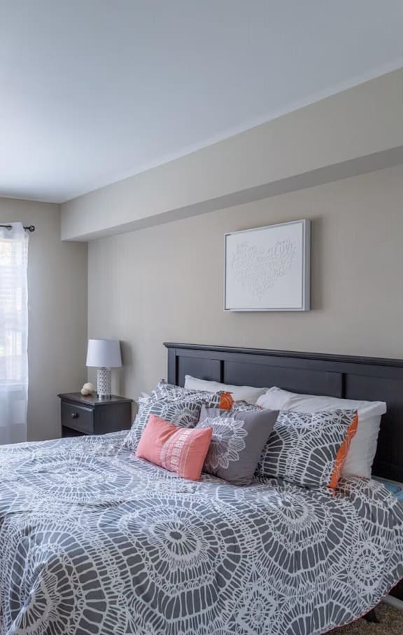 bed with photo on the wall above it and bedside table with lamp