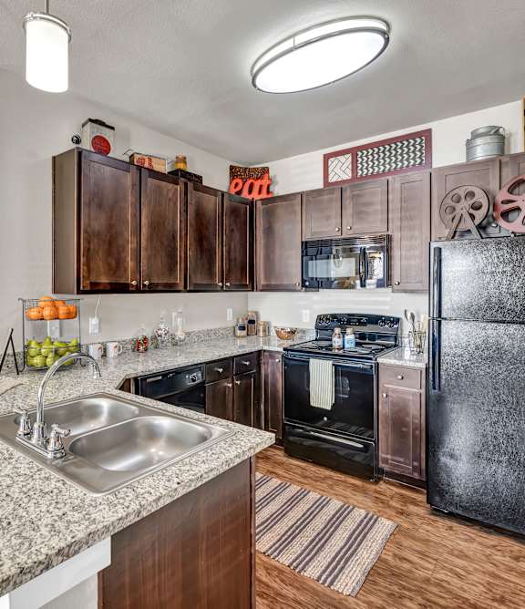 A kitchen with a sink, stove, and refrigerator.