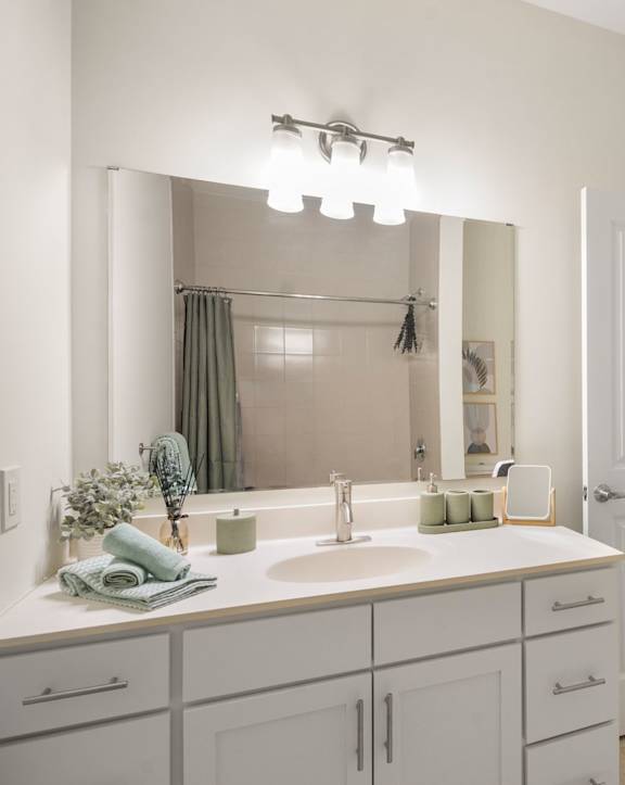 A bathroom with a white sink and a mirror above it.
