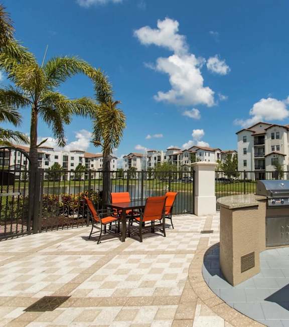 A sunny day at a resort with a palm tree and a building in the background.