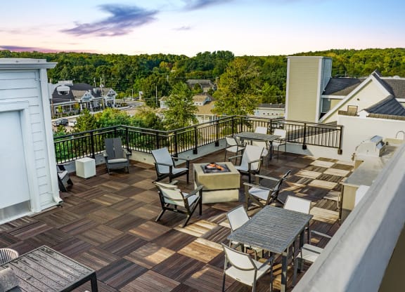 a patio with a fire pit and a dining table and chairs