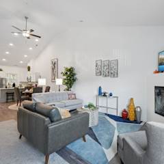 A living room with a grey couch, a fireplace, and a painting on the wall.