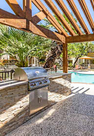 a backyard with a swimming pool and a barbecue grill